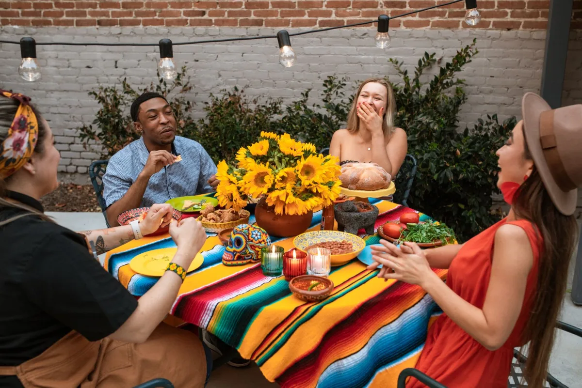 Friends laughing together over dinner, the kind of happy guests worth asking for a review