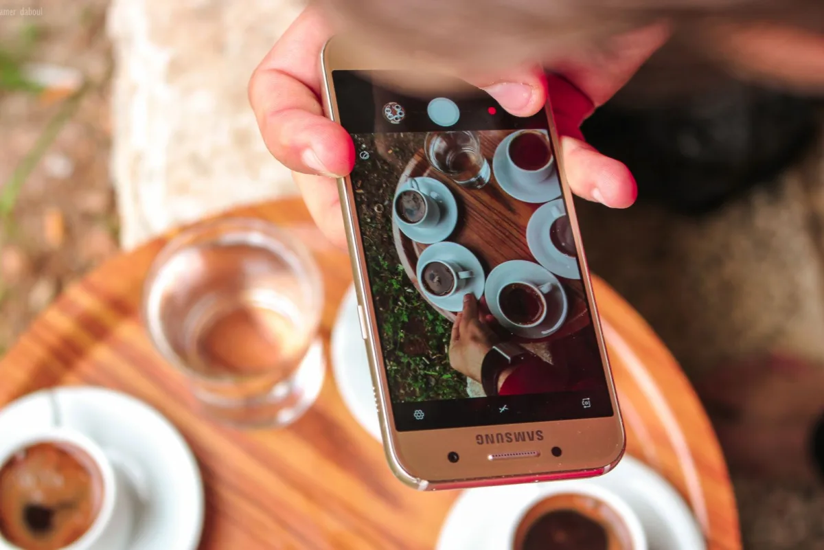 A guest using their phone at a cafe table, where a follow-up review link lands