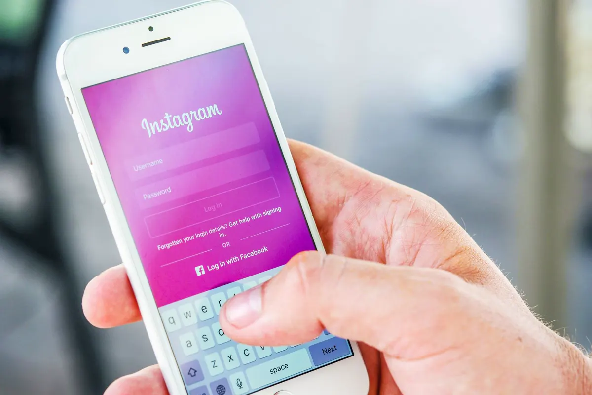 A hand holding a phone open to a social media app
