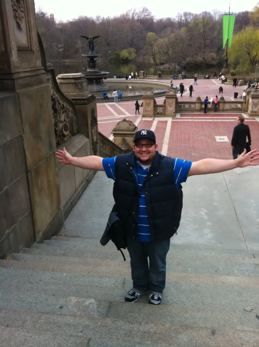 Daniel Ruiz with arms outstretched at Bethesda Terrace in Central Park, New York City