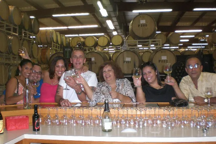 Daniel Ruiz raising a glass with family in a winery barrel room